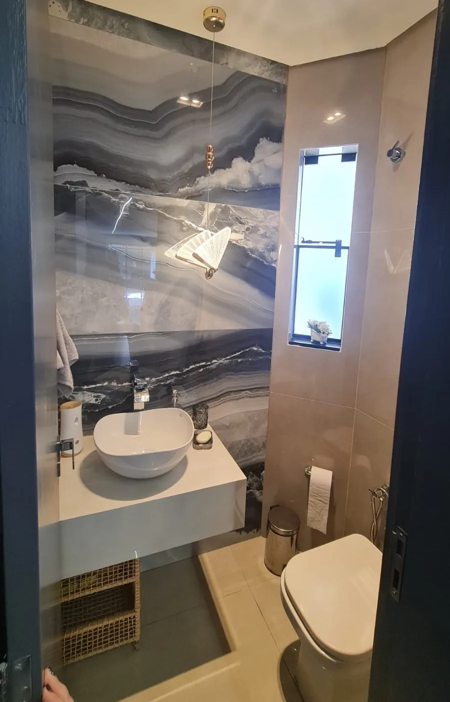 Banheiro moderno com revestimentos em mármore, cuba de apoio e iluminação embutida — Design de interiores